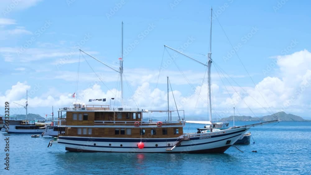 Beautiful liveaboard ship boat moored in idyllic, calm ocean in fishing village of Labuan Bajo, Flores island, Nusa Tenggara region of east Indonesia Beautiful liveaboard ship boat moored in idyllic, calm ocean in fishing village of Labuan Bajo, Flores island, Nusa Tenggara region of east Indonesia