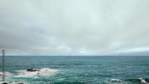 Rocky shore under blue sky and white clouds. White waves and moving white clouds Waimushan Seaside Scenic Area, Keelung, Taiwan photo