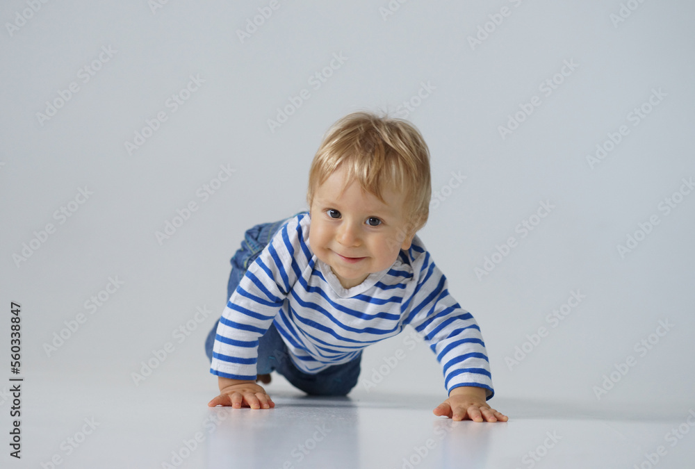 Little, happy and smiling cute baby in the studio. Portrait of a one year old baby. The concept of happiness. Little, happy and smiling cute baby in the studio. Portrait of a one year old baby. The concept of happiness.