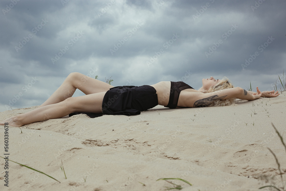 Sensual bare lady lying on beach scenic photography. Picture of person with overcast sky on background. High quality wallpaper. Photo concept for ads, travel blog, magazine, article Sensual bare lady lying on beach scenic photography. Picture of person with overcast sky on background. High quality wallpaper. Photo concept for ads, travel blog, magazine, article