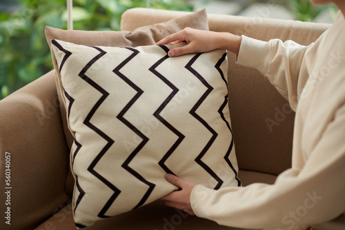 Canvas Print Cropped image of woman decorating couch in living room with throw pillow