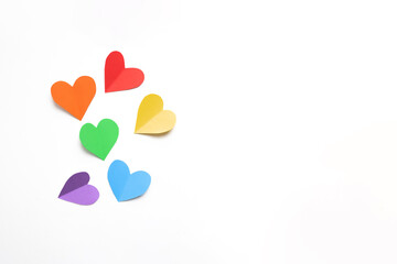 frame composition with rainbow colored paper hearts  on a white background. concept of valentine's day, lgbt, pride month. copy space. flat lay. top view.