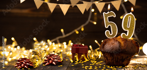 Number 59 golden festive burning candles in a cake, wooden holiday background. fifty nine years since the birth. the concept of celebrating a birthday, anniversary, holiday. Banner. photo