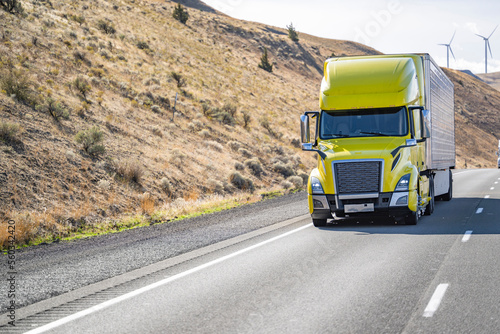 Wallpaper Mural Successful big rig yellow semi truck transporting cargo in refrigerator semi trailer driving uphill on the wide highway road Torontodigital.ca