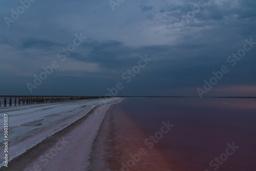 Beautiful view of pink salt lake in Kherson region  Ukraine  Europe. Bright wallpapers. Scenic photography of nature. Amazing seascape. Wooden poles in the water of a pink lake