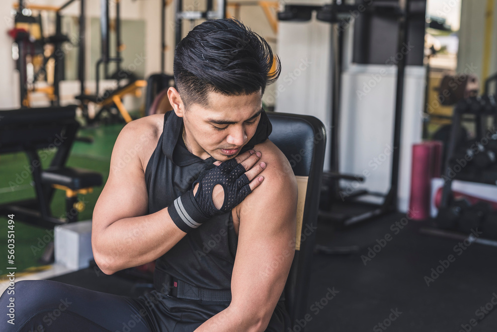 An asian man bothered by a bum shoulder. A possible mild or chronic rotator cuff injury at the gym. An asian man bothered by a bum shoulder. A possible mild or chronic rotator cuff injury at the gym.