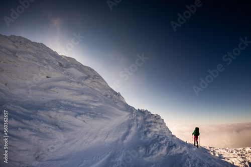 A woman walks in snowshoes in the mountains, winter trekking