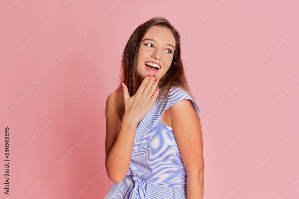 Shy laugh. Portrait of young emotive, beautiful girl posing over pink studio background. Concept of emotions, lifestyle, youth Shy laugh. Portrait of young emotive, beautiful girl posing over pink studio background. Concept of emotions, lifestyle, youth