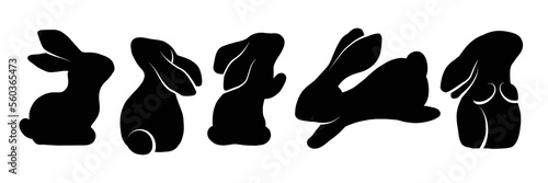 Vector set of black silhouettes of rabbits in various poses. Shadows of hares isolated from background.