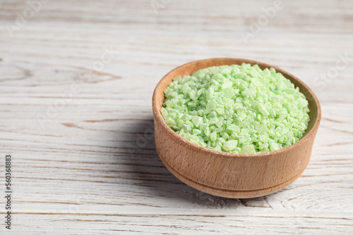 Green aromatic sea salt on white wooden table, closeup. Space for text
