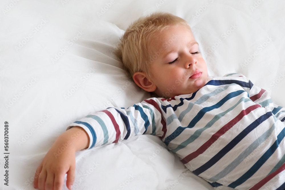 Young Child Sleeping on White Smooth Blanket. Little 3 Years Old Kids Sleeps Alone in Cozy Bedroom. Soft Textile. Sleepy Blonde Hair Baby Boy Dreaming in a Bed at home. Sign for banner. Space for text Young Child Sleeping on White Smooth Blanket. Little 3 Years Old Kids Sleeps Alone in Cozy Bedroom. Soft Textile. Sleepy Blonde Hair Baby Boy Dreaming in a Bed at home. Sign for banner. Space for text