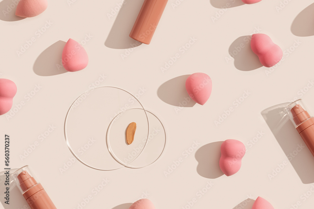 Makeup liquid foundation nude cream cosmetic bottle, cosmetic swatches on glass disk, beauty blender, sponges, make up puff on beige background with shadows. Tonal bb cream for nude skin color Makeup liquid foundation nude cream cosmetic bottle, cosmetic swatches on glass disk, beauty blender, sponges, make up puff on beige background with shadows. Tonal bb cream for nude skin color