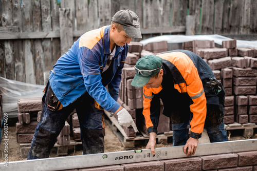 business, building, teamwork and people concept - group of smiling builders outdoors