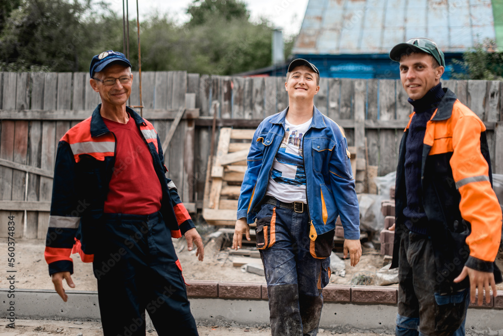 Obraz premium business, building, teamwork and people concept - group of smiling builders outdoors