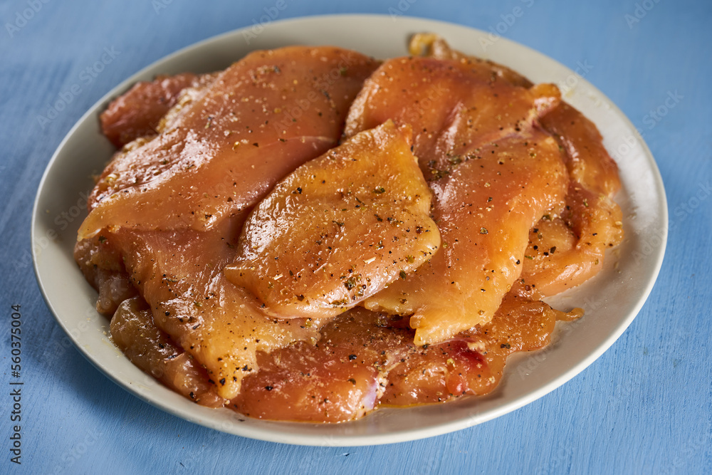 Seasoned chicken breast fillets on a plate Seasoned chicken breast fillets on a plate