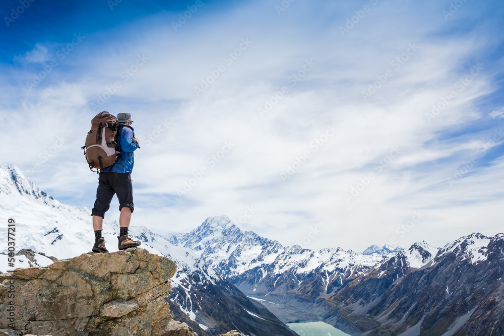 Hiker with backpack on the mountain top. Sport and active life concept