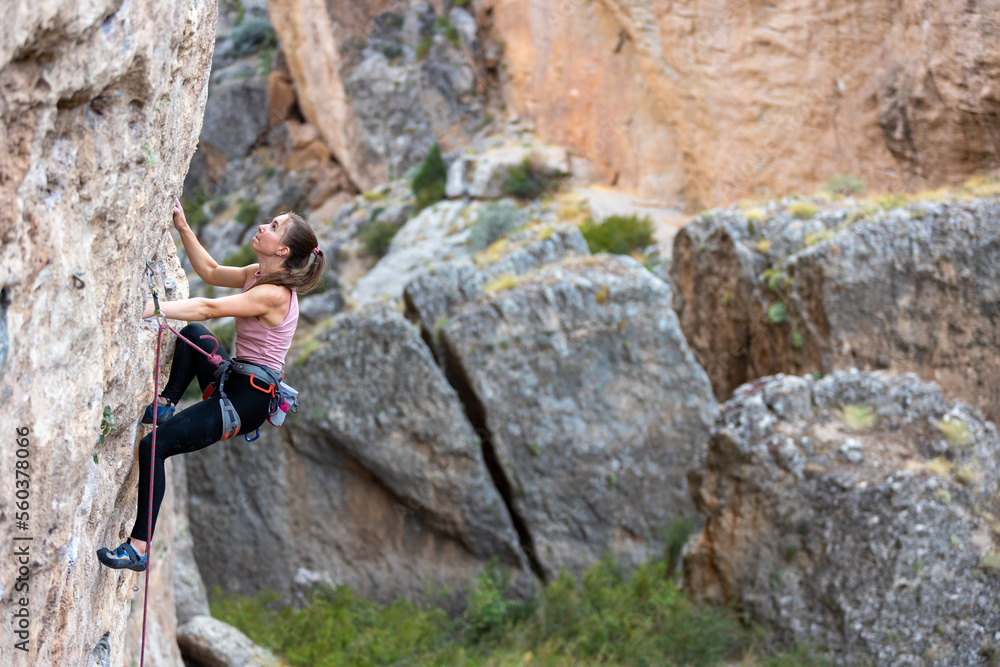 sport climbing. the girl overcomes the climbing route on the rock.