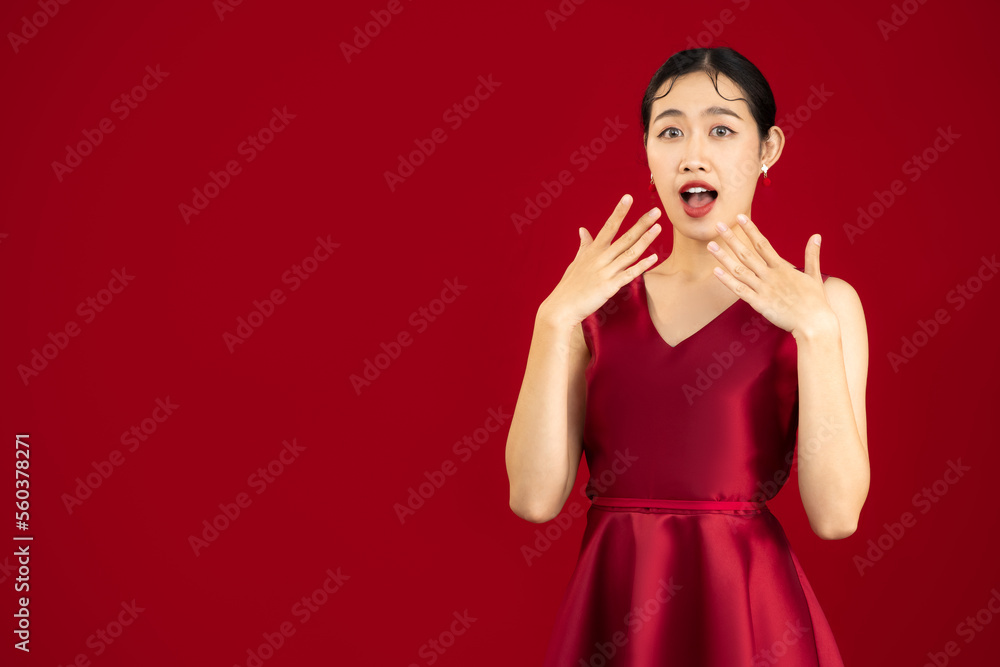 Asian woman wear red elegant dress posing surprised face on red color background. Asian woman wear red elegant dress posing surprised face on red color background.