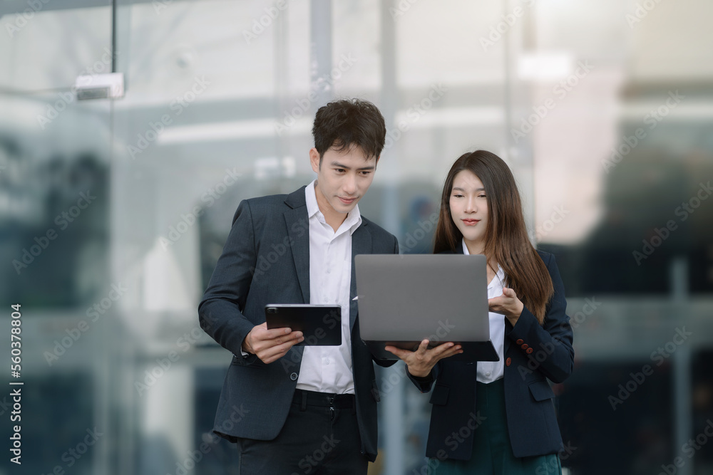 Professional investor working new start up project. Finance managers meeting.using laptop and digital tablet outside an office building. Professional investor working new start up project. Finance managers meeting.using laptop and digital tablet outside an office building.