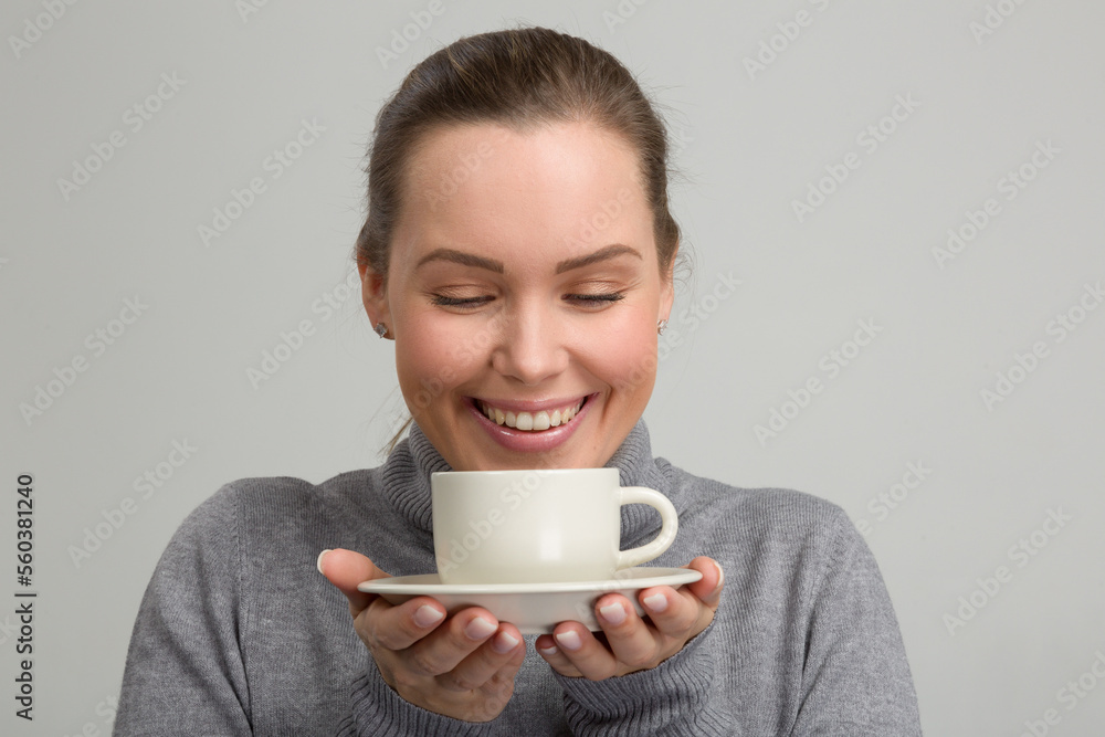 young woman with a cup in her hand looks very lucky and is enjoying her cup of coffee young woman with a cup in her hand looks very lucky and is enjoying her cup of coffee