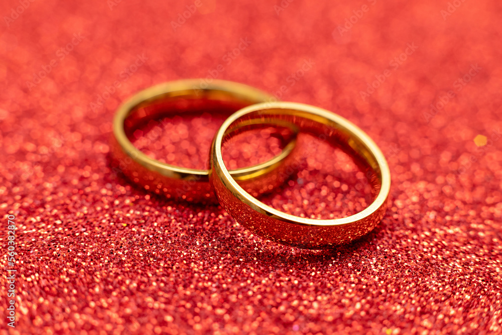 Will you marry me. Two golden wedding rings on red glitter background. Engagement marriage proposal wedding concept. St. Valentine's Day postcard. Banner on valentines day. Copy space Will you marry me. Two golden wedding rings on red glitter background. Engagement marriage proposal wedding concept. St. Valentine's Day postcard. Banner on valentines day. Copy space
