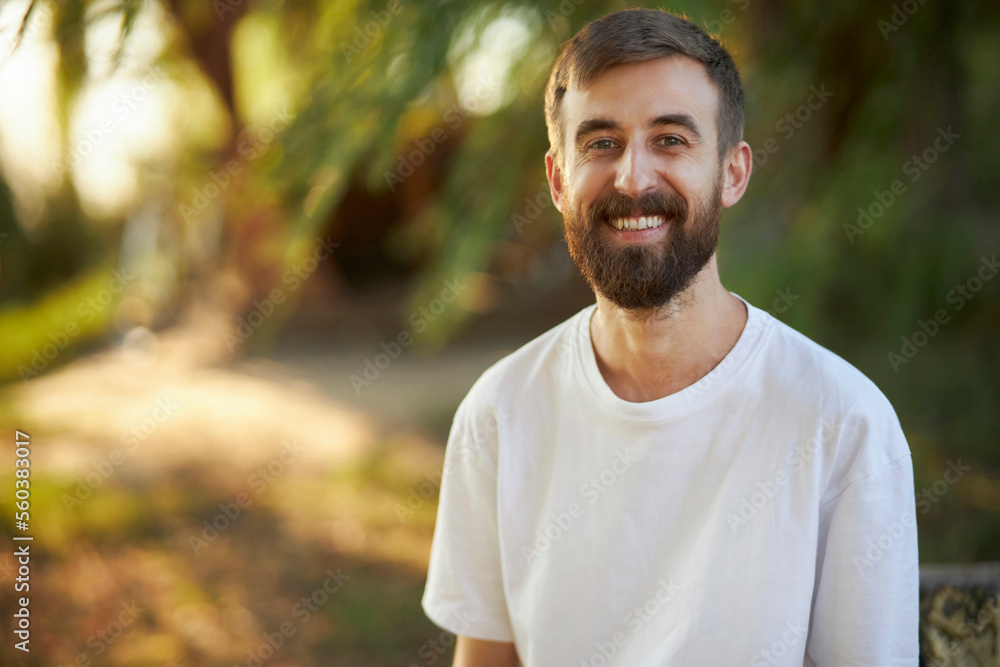 Cheerful man in a white t-shirt. Portrait of a cheerful man with a beard. Joy. Laughter. Smile 