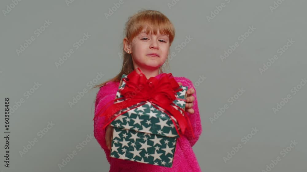Lovely smiling young preteen child girl kid presenting birthday gift box stretches out hands, offer wrapped present bonus, celebrating party. Little toddler children on studio gray background Lovely smiling young preteen child girl kid presenting birthday gift box stretches out hands, offer wrapped present bonus, celebrating party. Little toddler children on studio gray background