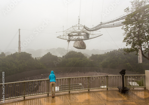 A woman stands next to the world's largest satellite dish at Arecibo Observatory in Puerto Rico. photo