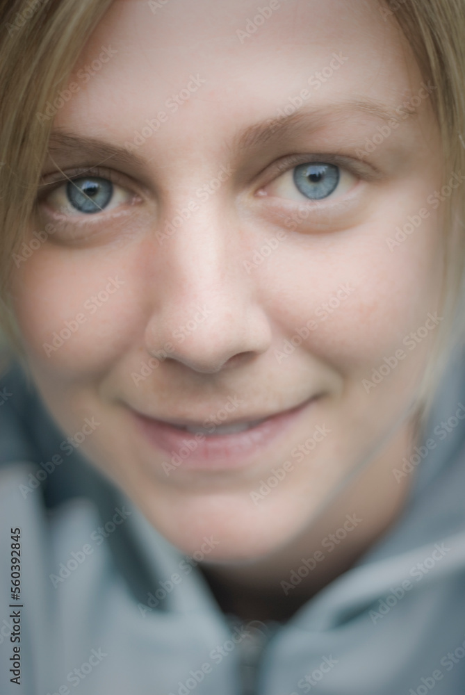 Soft close up portrait of a content young woman with blue eyes wearing a blue fleece jacket. Soft close up portrait of a content young woman with blue eyes wearing a blue fleece jacket.