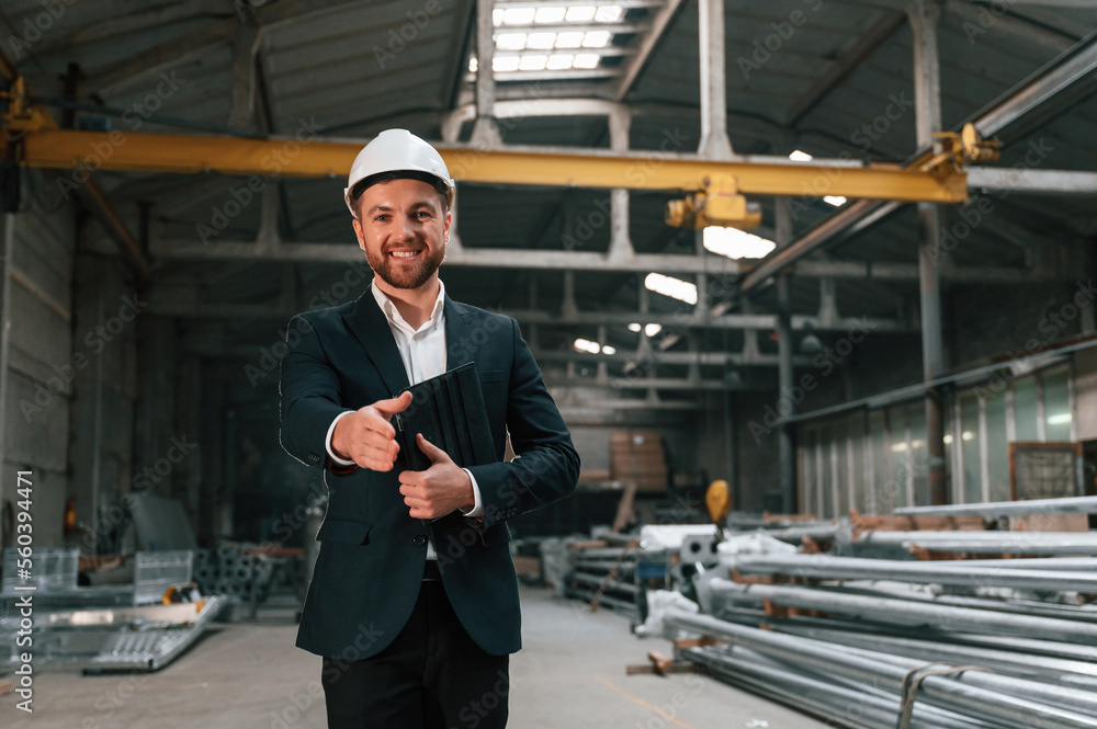 Giving the hand to shake. Manager in black formal wear at the factory Giving the hand to shake. Manager in black formal wear at the factory