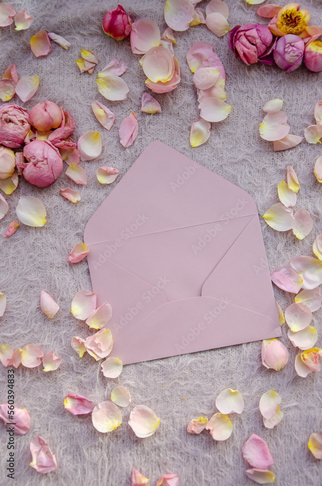 Craft pink envelope with small petals and rose buds on pink knitted background.Valentines Day background and Copy space for your text. Card design.