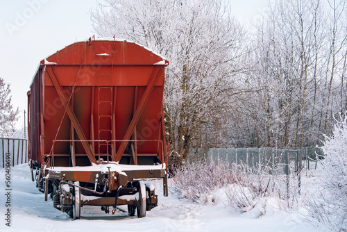 Carriages of a cargo train standing a snow covered railway line