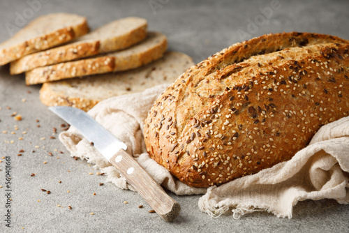 Artisan multigrain bread and knife on a towel.