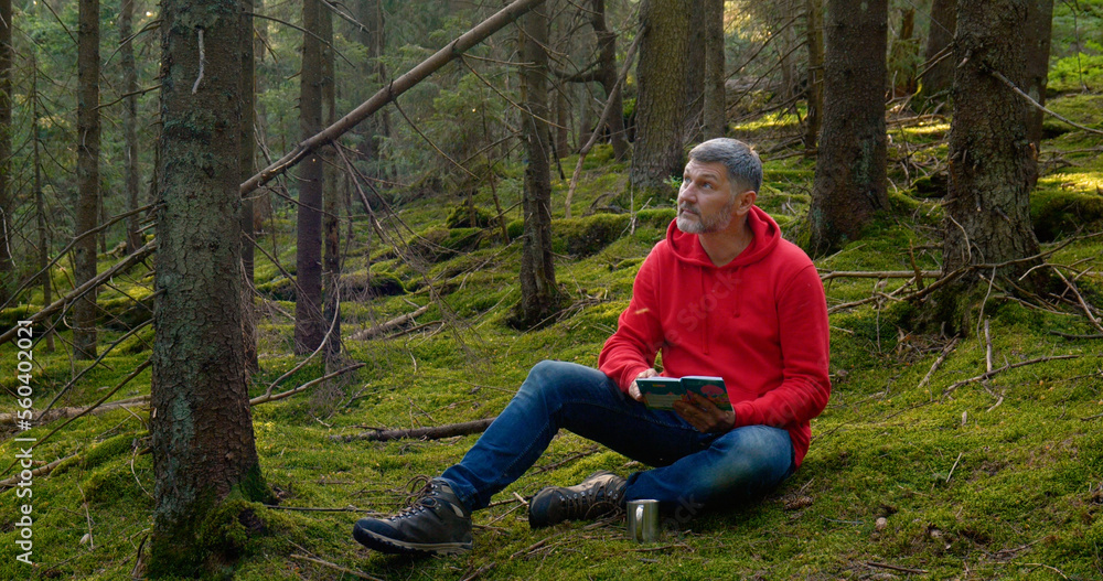 A man reading a book in a beautiful forest A man reading a book in a beautiful forest