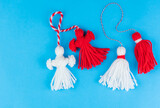 Traditional Martisor - symbol of holiday 1 March, Martenitsa, Baba Marta, beginning of spring and seasons changing in Romania, Bulgaria, Moldova. Greeting and post card for holidays. Blue background.
