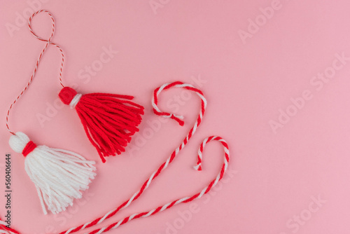 Traditional Martisor - symbol of holiday 1 March, Martenitsa, Baba Marta, beginning of spring and seasons changing in Romania, Bulgaria, Moldova. Greeting and post card for holidays. Pink background. photo