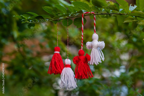 Traditional Martisor on green tree branch - symbol of 1 March, Martenitsa, Baba Marta, beginning of spring and seasons changing in Romania, Bulgaria, Moldova. Greeting and post card for holidays. photo