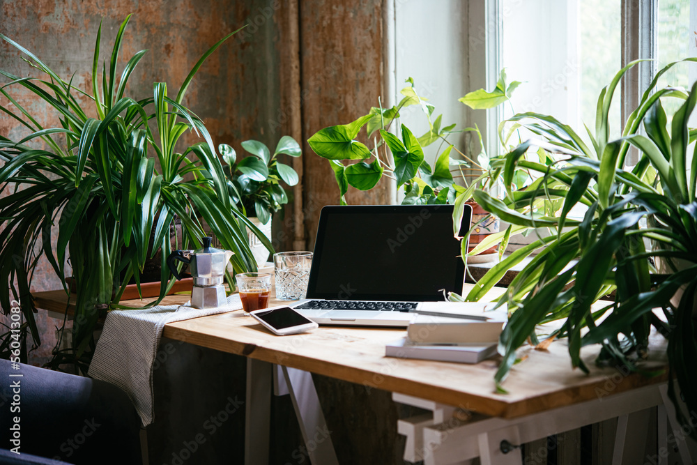 Enjoying working from an atmospheric home office full of green plants.