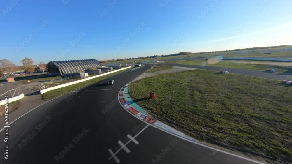 aerial filming of a circuit race on an asphalt circuit, fpv drone, racing cars go fast, time trials, sharp turns aerial filming of a circuit race on an asphalt circuit, fpv drone, racing cars go fast, time trials, sharp turns