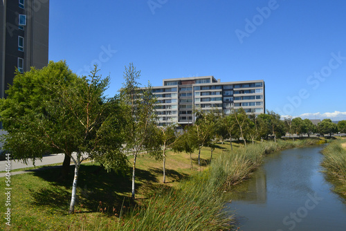 a river and some green areas near an urbanization of buildings and houses © gustavo