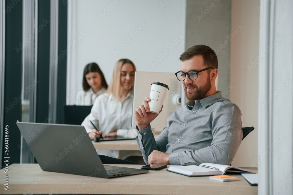 Front view of man. Successful team are working together in the office. Conception of business Front view of man. Successful team are working together in the office. Conception of business