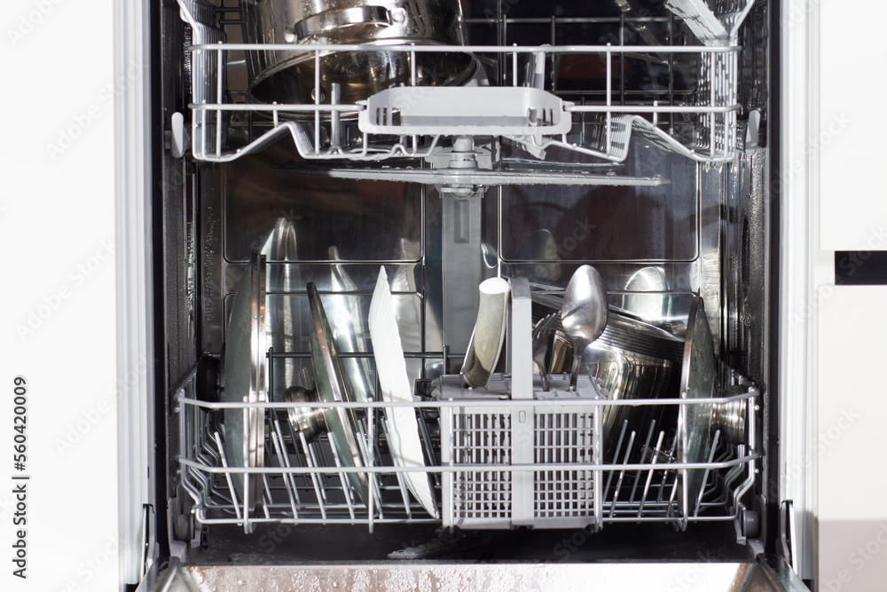 Cutlery and plates after washer in the dishwasher.
Clean dishes in dishwasher machine after washing cycle.