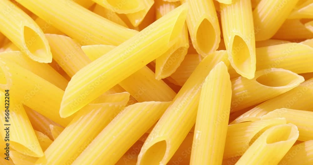 Uncooked pasta close-up. Dry penne macro shot. Macaroni in bright sunlight. Uncooked pasta close-up. Dry penne macro shot. Macaroni in bright sunlight.