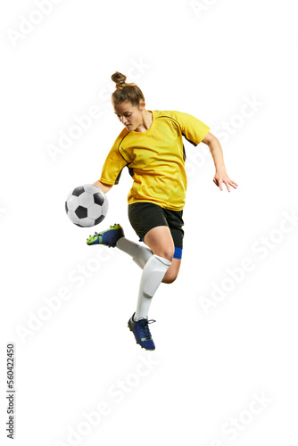 Young professional female football player in motion, playing football, soccer, hitting ball in a jump isolated over white background