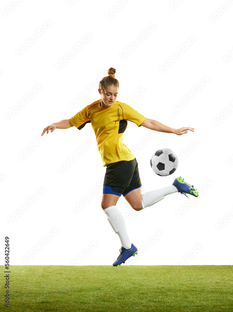 Young woman, professional female football player in motion, training, playing football, soccer isolated over white background