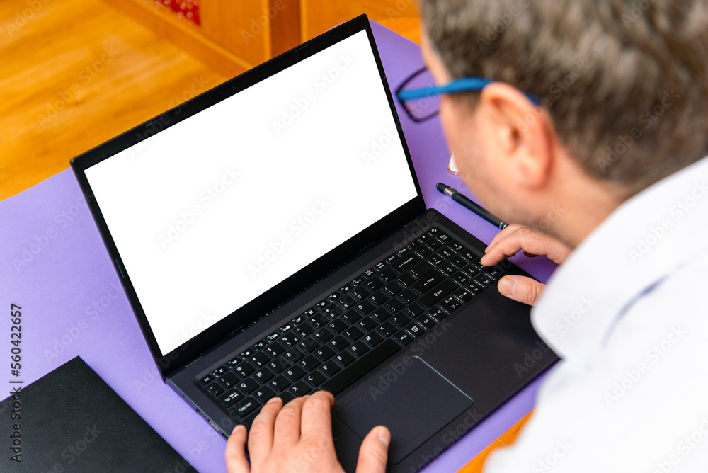 Caucasian businessman working on his laptop with copy space on a screen.Using laptop computer looking at mockup empty screen.Selective focus. Caucasian businessman working on his laptop with copy space on a screen.Using laptop computer looking at mockup empty screen.Selective focus.