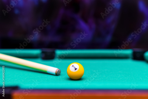 Billiard pool game one ball with cue on billiard table with green cloth.Blurred background.