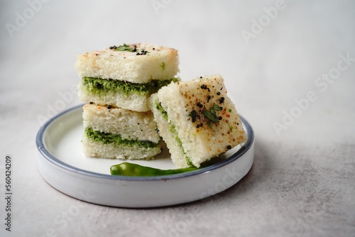 White Dhokla sandwich with green chutney, selective focus photo