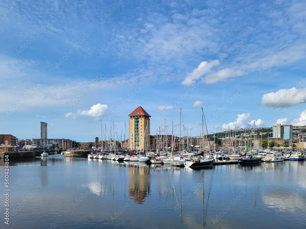 Apartment buildings surround the waterfront area on the River Tawe at the Swansea Marina. - obrazy, fototapety, plakaty 