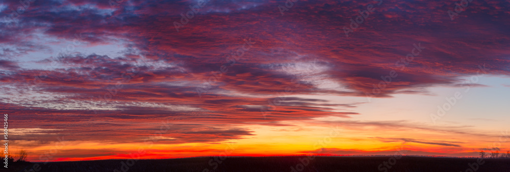 Panoramic view of colorful sunset sky with clouds. At dusk from a low angle of view.